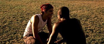 Movie still from “All the Boys Love Mandy Lane” (2006), directed by Jonathan Levine – Two young men sitting on the grass talking to each other; Medium shot, Over the shoulder angle