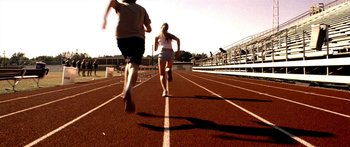 Movie still from “All the Boys Love Mandy Lane” (2006), directed by Jonathan Levine – Two people running on a track on a sunny day; Wide shot, High angle