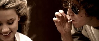 Movie still from “All the Boys Love Mandy Lane” (2006), directed by Jonathan Levine – A person is smoking a cigarette in a dark room; Extreme Close Up shot, Over the shoulder angle