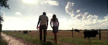 Movie still from “All the Boys Love Mandy Lane” (2006), directed by Jonathan Levine – A man and a woman standing in a field holding hands; Wide shot, Low angle