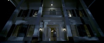 Movie still from “All the Boys Love Mandy Lane” (2006), directed by Jonathan Levine – A person standing in front of a building at night; Wide shot, Low angle