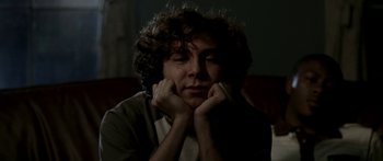 Movie still from “All the Boys Love Mandy Lane” (2006), directed by Jonathan Levine – A man with curly brown hair sitting on a couch; Close Up shot, Low angle