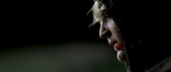 Movie still from “All the Boys Love Mandy Lane” (2006), directed by Jonathan Levine – A person's face with a dark background; Extreme Close Up shot, Over the shoulder angle