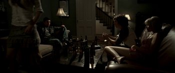 Movie still from “All the Boys Love Mandy Lane” (2006), directed by Jonathan Levine – Two people sitting in a living room drinking wine; Wide shot, Over the shoulder angle