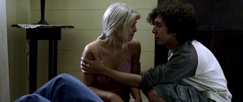 Movie still from “All the Boys Love Mandy Lane” (2006), directed by Jonathan Levine – A man and a woman sitting on the floor; Medium shot, Over the shoulder angle