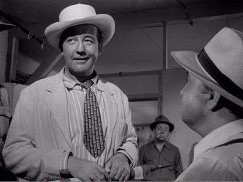 Movie still from “All the King's Men” (1949), directed by Robert Rossen – A man wearing a hat and a tie talking to another man wearing a hat and a tie; Medium shot, Over the shoulder angle