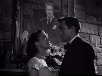 Movie still from “All the King's Men” (1949), directed by Robert Rossen – A man and a woman standing next to each other in front of a portrait; Medium shot, Low angle
