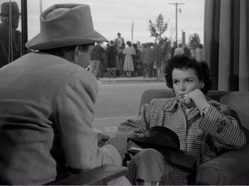 Movie still from “All the King's Men” (1949), directed by Robert Rossen – An old photo of two people sitting in a chair; Medium shot, Over the shoulder angle