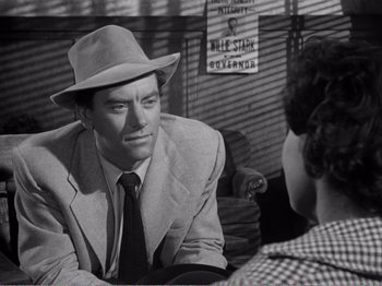 Movie still from “All the King's Men” (1949), directed by Robert Rossen – A man in a suit and a hat talking to another man; Close Up shot, Over the shoulder angle