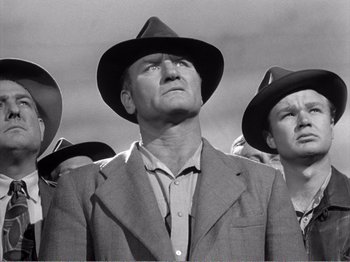 Movie still from “All the King's Men” (1949), directed by Robert Rossen – A group of people wearing hats and suits; Medium shot, Low angle