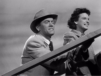 Movie still from “All the King's Men” (1949), directed by Robert Rossen – An old photo of a man and a woman leaning on a railing; Medium shot, Low angle