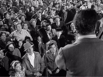 Movie still from “All the King's Men” (1949), directed by Robert Rossen – A crowd of people wearing hats and a microphone; Wide shot, High angle