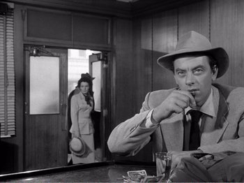 Movie still from “All the King's Men” (1949), directed by Robert Rossen – A man in a hat and a woman in a hat; Medium shot, Over the shoulder angle