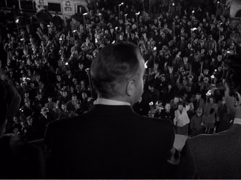 Movie still from “All the King's Men” (1949), directed by Robert Rossen – A man in a crowd of people with cell phones in their hands; Medium shot, High angle