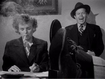 Movie still from “All the King's Men” (1949), directed by Robert Rossen – Two men sitting at a table smoking a cigarette; Medium shot, Low angle