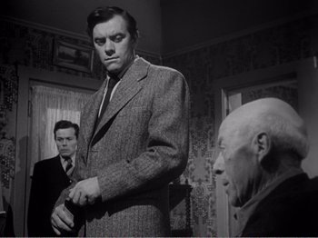 Movie still from “All the King's Men” (1949), directed by Robert Rossen – A black and white photo of a man in a suit; Medium shot, Low angle