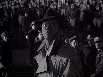 Movie still from “All the King's Men” (1949), directed by Robert Rossen – A man wearing a hat standing in front of a group of people; Medium shot, High angle