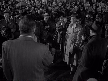 Movie still from “All the King's Men” (1949), directed by Robert Rossen – A group of people standing in front of a crowd; Medium shot, High angle