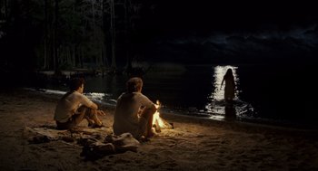 Movie still from “All the King's Men” (2006), directed by Steven Zaillian – Two men sitting on the beach near a fire; Extreme Wide shot, High angle
