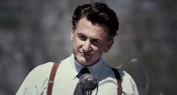 Movie still from “All the King's Men” (2006), directed by Steven Zaillian – A person with a microphone; Close Up shot, Over the shoulder angle