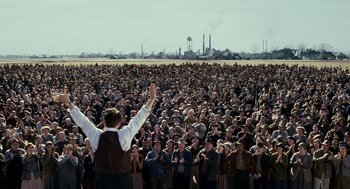 Movie still from “All the King's Men” (2006), directed by Steven Zaillian – A crowd of people standing in front of a man with his hands up; Wide shot, High angle