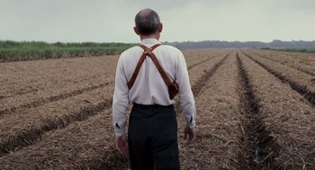 Movie still from “All the King's Men” (2006), directed by Steven Zaillian – An older man wearing suspenders in an open field; Medium shot, Over the shoulder angle
