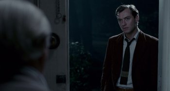 Movie still from “All the King's Men” (2006), directed by Steven Zaillian – A man standing in front of a mirror wearing a suit and tie; Medium shot, Over the shoulder angle