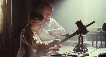 Movie still from “All the King's Men” (2006), directed by Steven Zaillian – A man and a boy working on a project together; Medium shot, Low angle