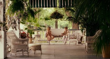Movie still from “All the King's Men” (2006), directed by Steven Zaillian – Two women sitting on a bench in a porch; Wide shot, High angle