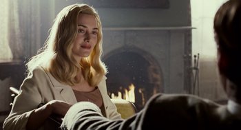 Movie still from “All the King's Men” (2006), directed by Steven Zaillian – A woman sitting in front of a fire place; Medium shot, Over the shoulder angle