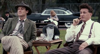 Movie still from “All the King's Men” (2006), directed by Steven Zaillian – A group of people sitting around a wooden table; Medium shot, Over the shoulder angle
