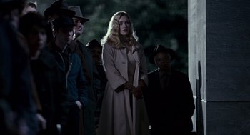 Movie still from “All the King's Men” (2006), directed by Steven Zaillian – A group of people standing next to each other in the dark; Medium shot, Over the shoulder angle