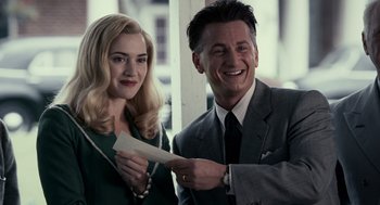 Movie still from “All the King's Men” (2006), directed by Steven Zaillian – A man and a woman standing next to each other holding papers; Medium shot, Over the shoulder angle