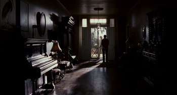Movie still from “All the King's Men” (2006), directed by Steven Zaillian – A man standing in front of an open front door; Wide shot, Over the shoulder angle