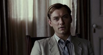 Movie still from “All the King's Men” (2006), directed by Steven Zaillian – A man sitting in a chair wearing a suit and tie; Close Up shot, Over the shoulder angle