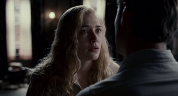 Movie still from “All the King's Men” (2006), directed by Steven Zaillian – A young woman looking at a man in a dark room; Close Up shot, Over the shoulder angle