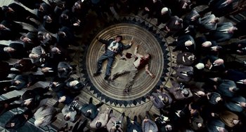 Movie still from “All the King's Men” (2006), directed by Steven Zaillian – A group of people standing around a man laying on the ground; Wide shot, Overhead angle