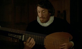 Movie still from “Tous les matins du monde” (1991), directed by Alain Corneau – A man in a black shirt is holding a guitar; Close Up shot, Over the shoulder angle