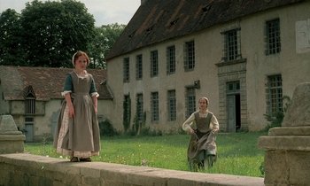 Movie still from “Tous les matins du monde” (1991), directed by Alain Corneau – Two women in old - fashioned dress standing in front of an old house; Wide shot, Low angle