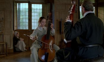 Movie still from “Tous les matins du monde” (1991), directed by Alain Corneau – A woman playing a cello while a man plays a guitar; Medium shot, Low angle