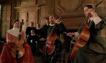 Movie still from “Tous les matins du monde” (1991), directed by Alain Corneau – A group of people sitting in a room playing musical instruments; Medium shot, Low angle