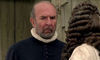 Movie still from “Tous les matins du monde” (1991), directed by Alain Corneau – An older man wearing a black and white outfit; Close Up shot, Over the shoulder angle