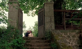Movie still from “Tous les matins du monde” (1991), directed by Alain Corneau – A bride and groom sitting on the steps of an old building; Wide shot, High angle
