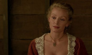 Movie still from “Tous les matins du monde” (1991), directed by Alain Corneau – A woman in a brown and white dress with a gold necklace; Close Up shot, Over the shoulder angle