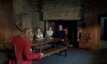 Movie still from “Tous les matins du monde” (1991), directed by Alain Corneau – A group of people sitting around a table; Wide shot, High angle