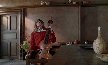 Movie still from “Tous les matins du monde” (1991), directed by Alain Corneau – A person sitting at a table playing a cello; Medium shot, Low angle