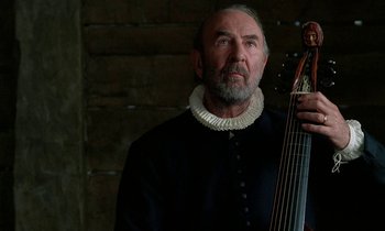 Movie still from “Tous les matins du monde” (1991), directed by Alain Corneau – An older man with a beard holding a guitar; Close Up shot, Over the shoulder angle