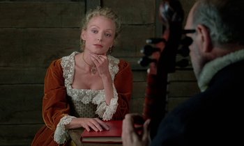 Movie still from “Tous les matins du monde” (1991), directed by Alain Corneau – A woman dressed in period clothing looking into a mirror while holding a book; Close Up shot, Over the shoulder angle
