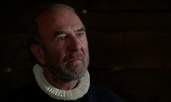 Movie still from “Tous les matins du monde” (1991), directed by Alain Corneau – An older man with a beard wearing a white collar; Close Up shot, Over the shoulder angle