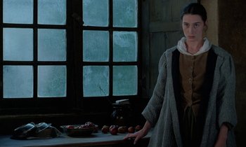 Movie still from “Tous les matins du monde” (1991), directed by Alain Corneau – A woman standing in front of a table with apples; Medium shot, Low angle